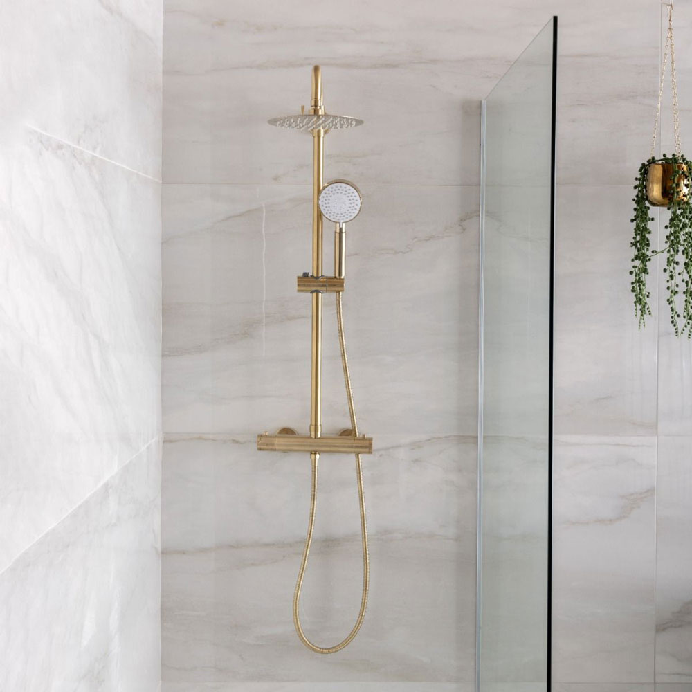 Gold, brushed brass traditional shower head in wet room.