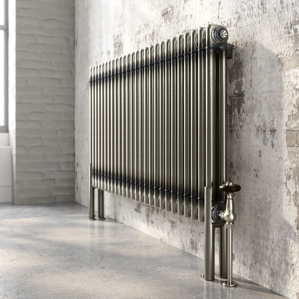 a raw metal radiator sitting in front of an exposed wall