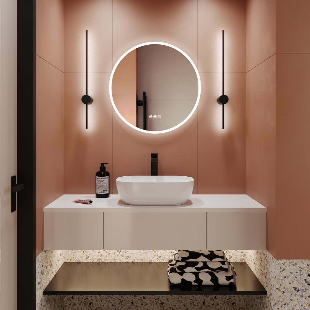Pink bathroom scheme with illuminated mirror mounted on the wall, featuring white vanity unit and counter top basin.