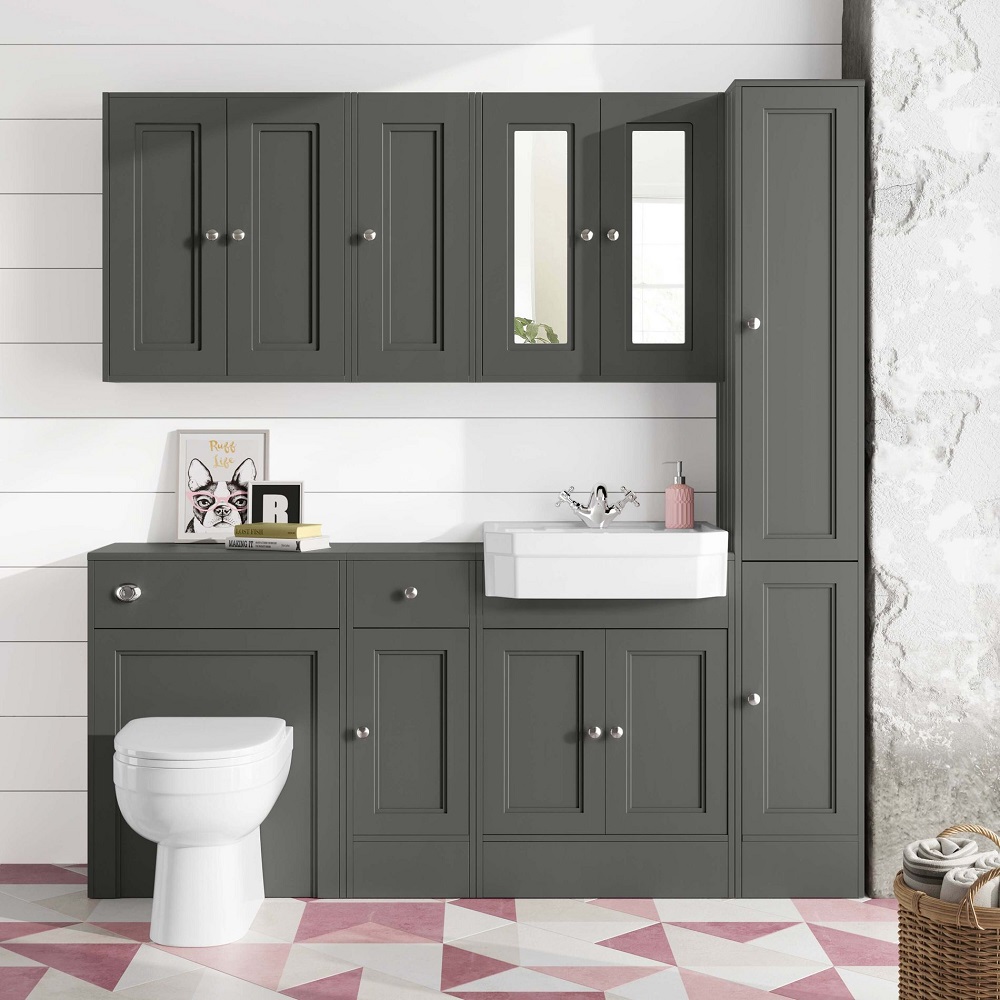 Contemporary bathroom with sleek dark grey cabinetry, a geometric pink and white floor, paired with charming personal touches like a framed sketch and decorative items on the counter.