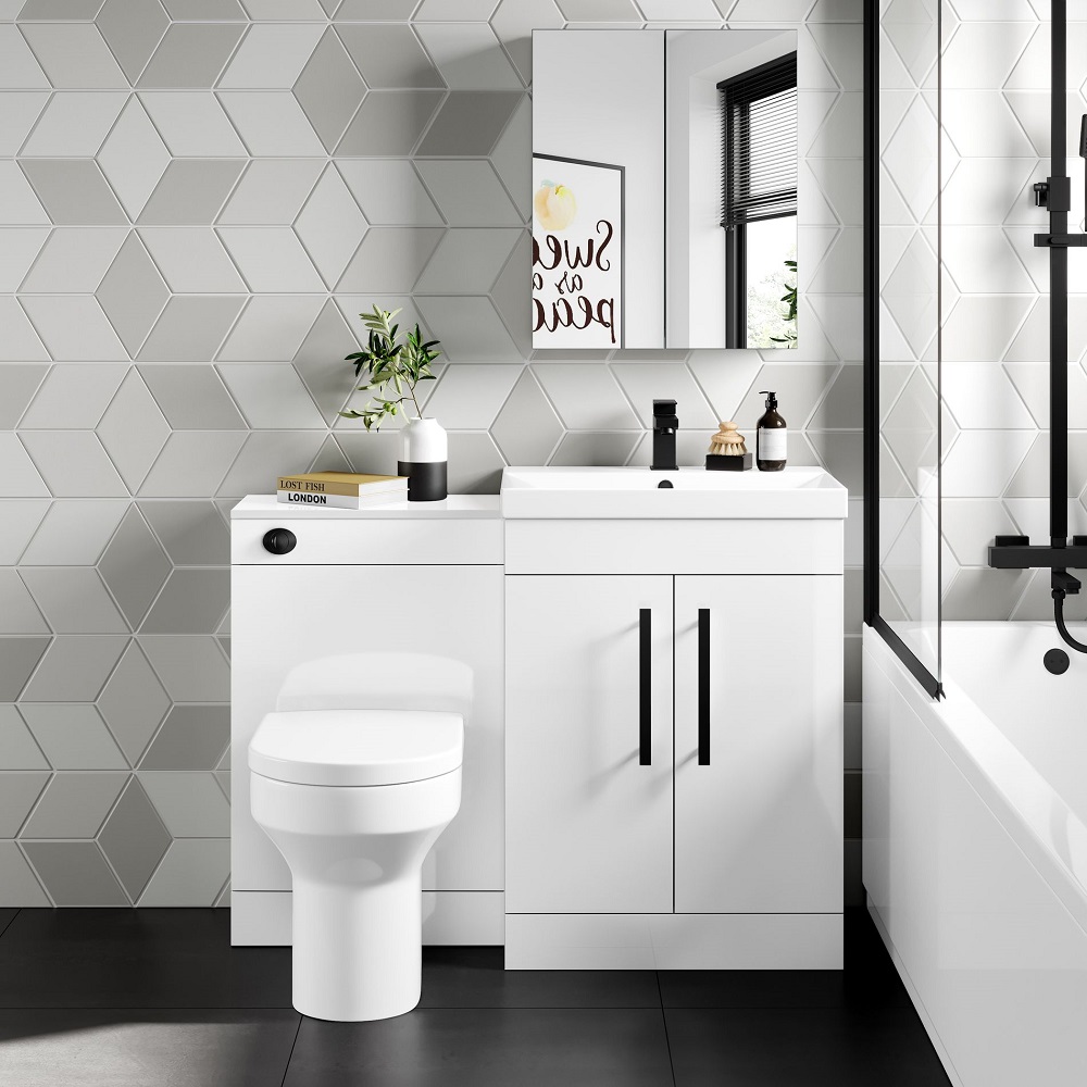 Stylish bathroom featuring geometric grey wall tiles, a white vanity with modern fixtures, framed art saying 'Sweat & Repeat', and a glimpse of a sleek shower door.