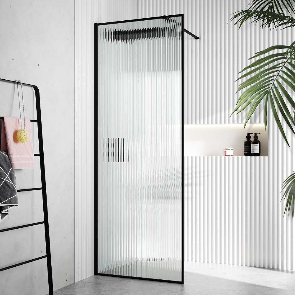 A modern bathroom with a textured, matt black framed fluted shower glass panel, complemented by a corrugated wall, green plant and black ladder towel rack. 
