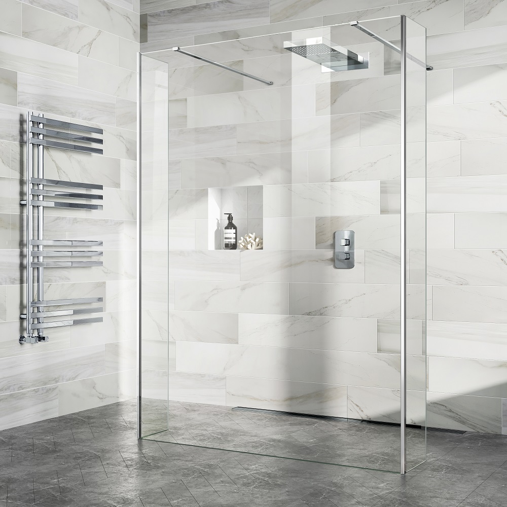 A modern, minimalistic bathroom featuring a walk-in shower with transparent glass walls, marble wall tiles, and a rainfall shower head. A chrome heated towel rack and carefully placed bathroom accessories complement the luxurious feel.