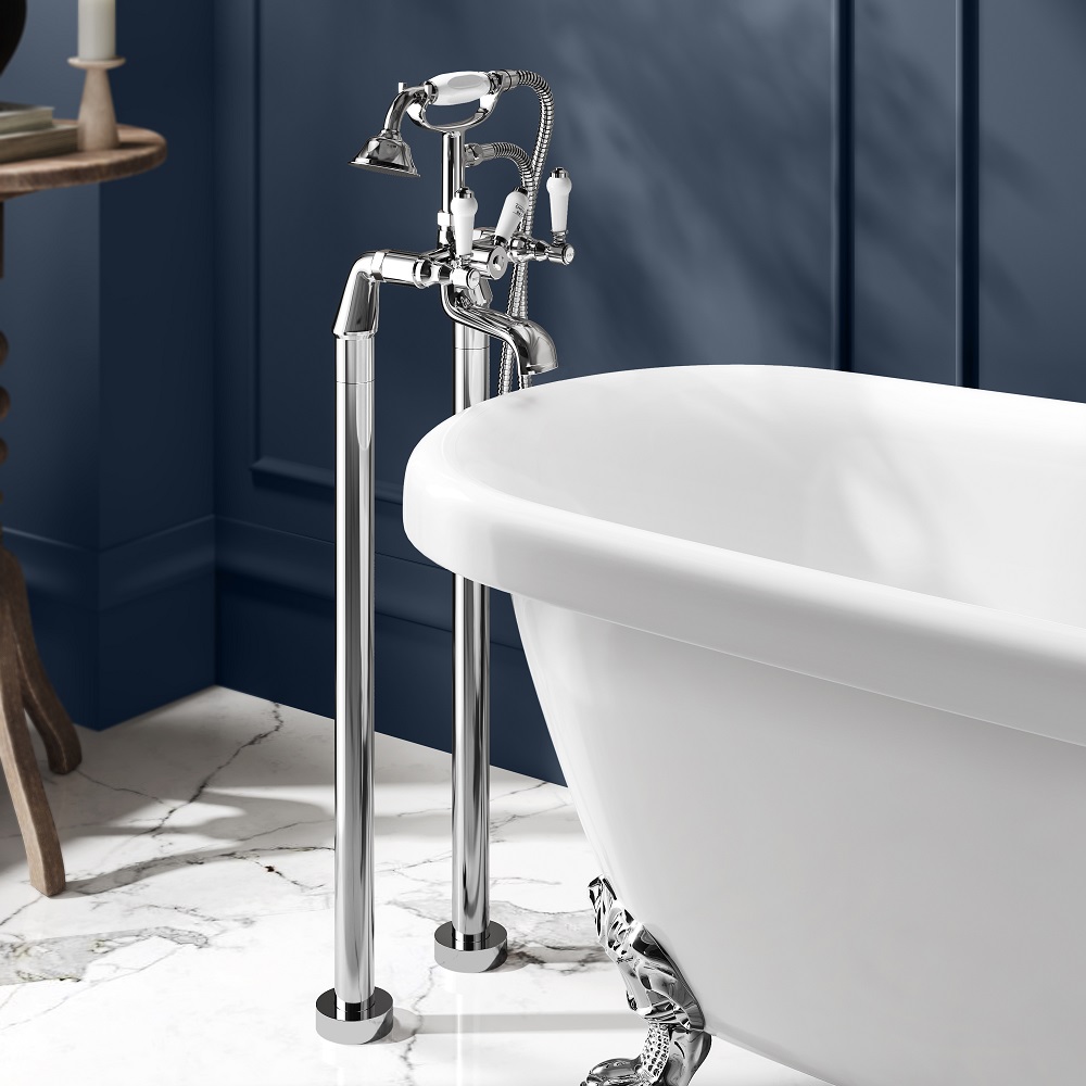 Sleek chrome freestanding bath shower mixer tap, with a classic telephone hand shower design, poised next to a white roll-top bathtub. The deep blue panelled wall provides a striking backdrop, while the marble floor adds a touch of timeless luxury to the bathroom setting. 