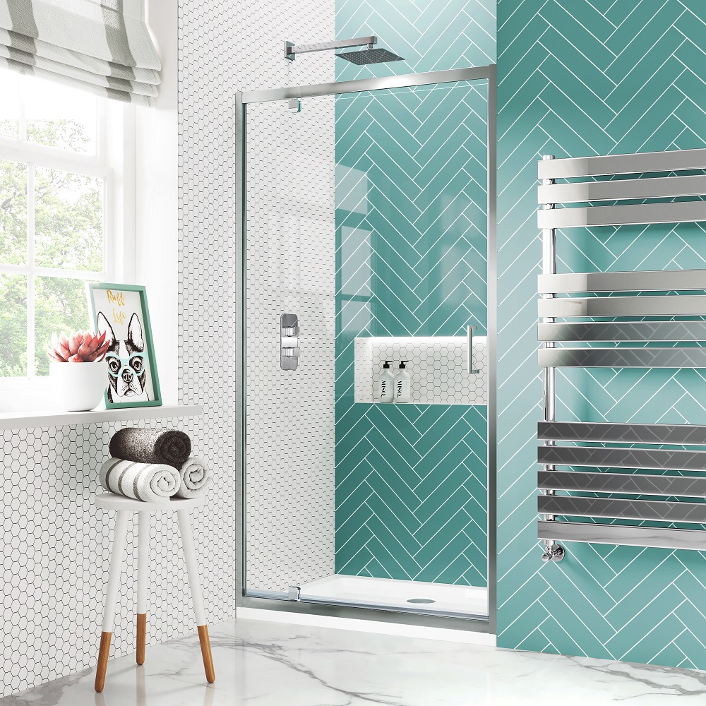 Modern bathroom with a white hexagonal tile floor, teal herringbone pattern shower tiles, and a glass pivot shower door. Features include a rainfall showerhead, digital temeprature control, a heated towel rack, and decorative elements like a framed dog illustration and rolled towels on a white stool.